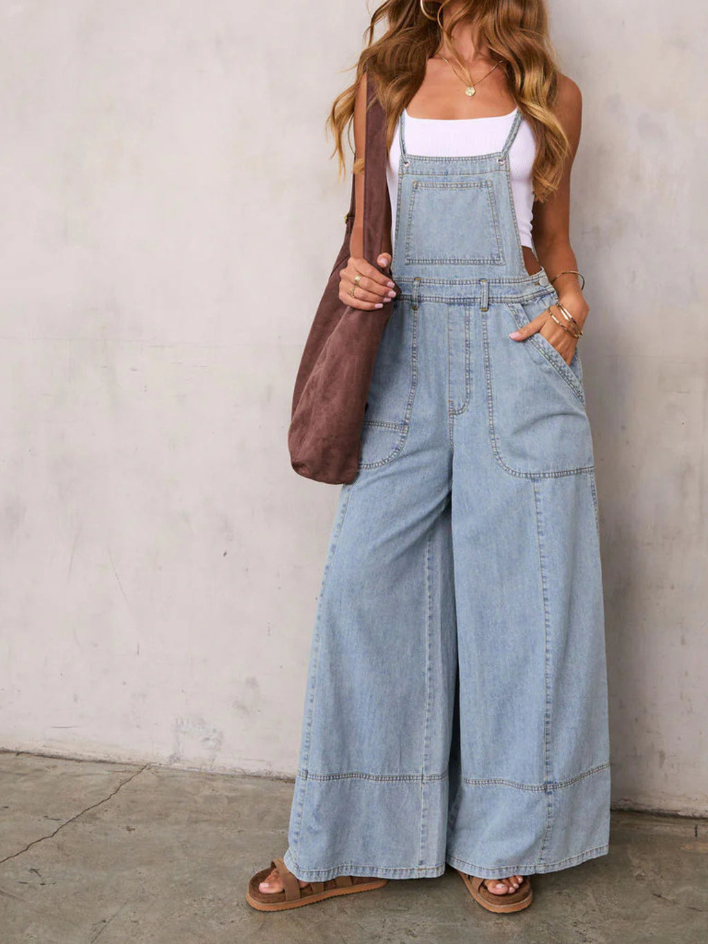 Relaxed fit wide-leg denim overalls jumpsuit by Trendsi, featuring adjustable straps and front pockets, laid flat.